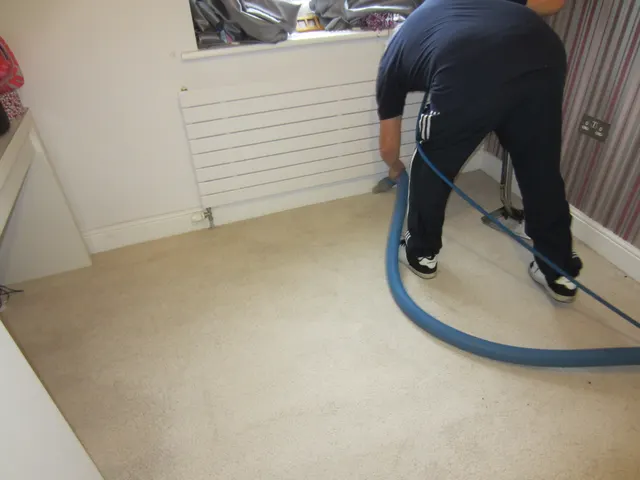 Cleaning along the carpet by the radiator